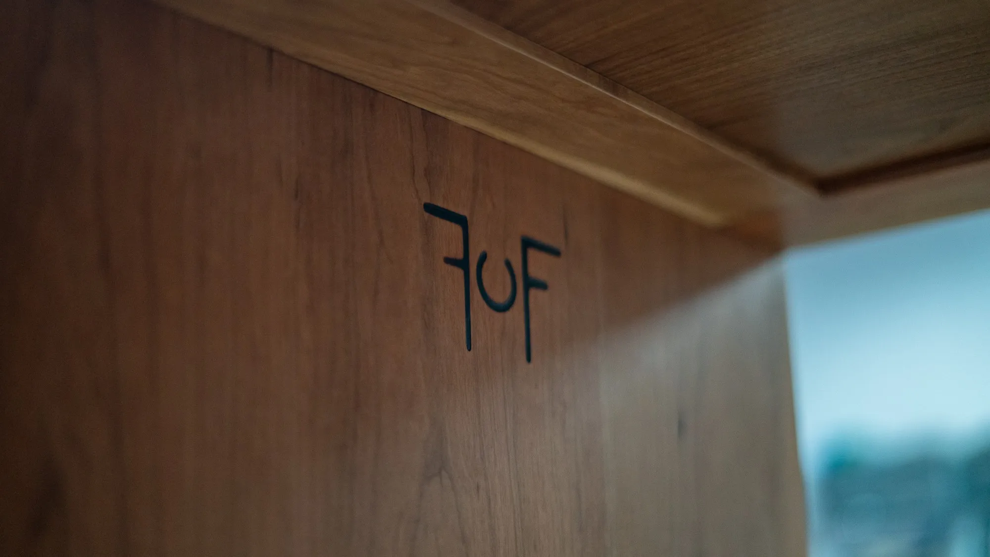 The Ferris maker's mark branded into the walnut inside the cabinet, lit from the open side.